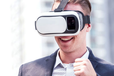 Smiling businessman virtual reality in city