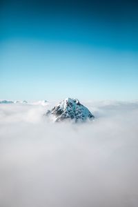 Snowcapped mountain amidst clouds against sky
