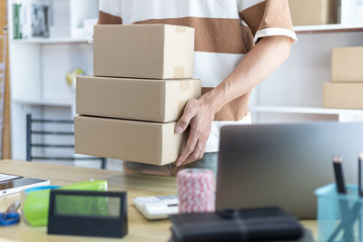 Midsection of woman holding box