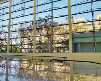 Low angle view of glass building against sky