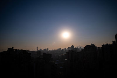 Silhouette buildings against sky during sunset