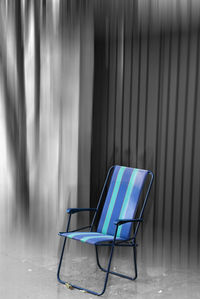 Empty chair against wall