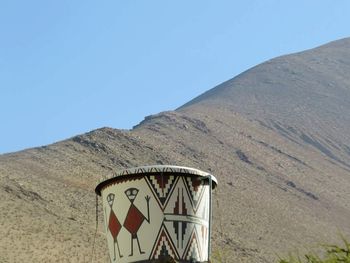 Information sign on mountain against clear blue sky