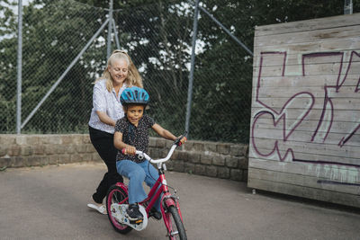 Mother teaching daughter to ride bike