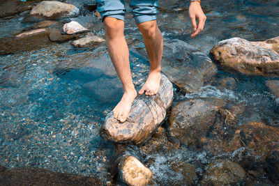 Low section of man standing on rock