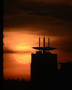 Silhouette tower against sky during sunset