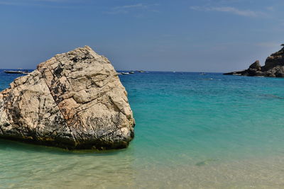 Rock formation in sea against sky