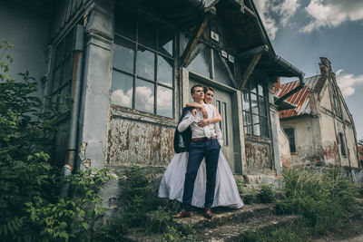 Woman standing by abandoned house