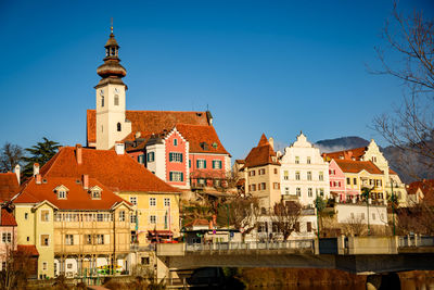 View of buildings in city against clear blue sky