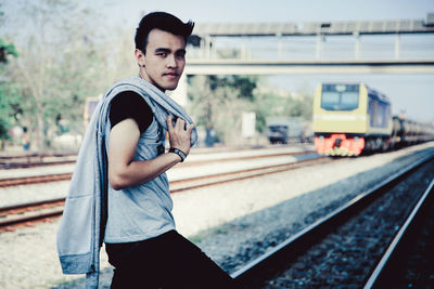 Full length of young man standing at railroad station