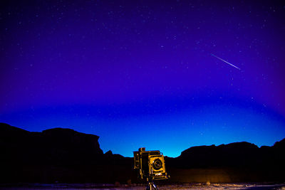 Time lapse photography of rocky mountains with stars in sky