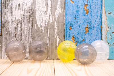 Row of plastic containers on table against wall