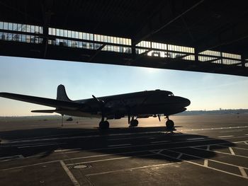 Airplane on airport runway against sky