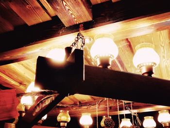 Low angle view of illuminated light bulbs hanging in restaurant