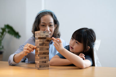 Mother and daughter playing jenga at home