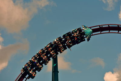 Low angle view of chain swing ride against sky