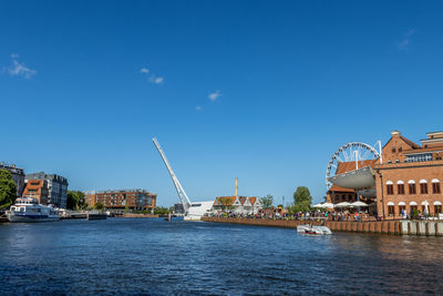 River in city against blue sky