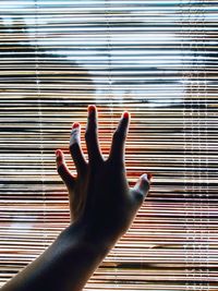 Close-up of hand touching window