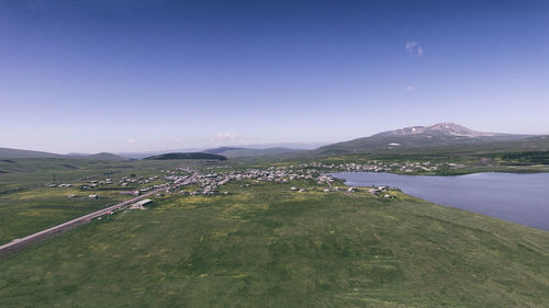 Scenic view of land and mountains against clear sky