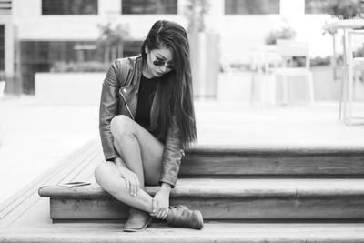 Full length of woman sitting outdoors