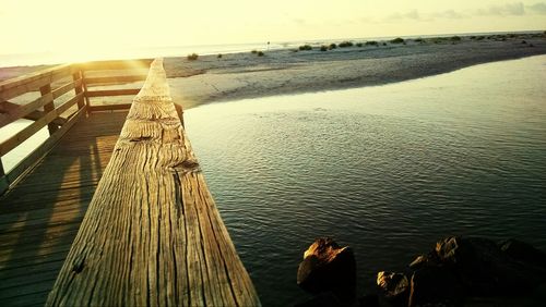 Pier on sea at sunset