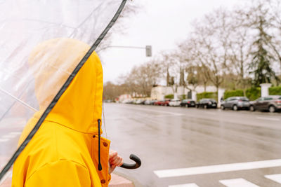 Rear view of woman holding umbrella