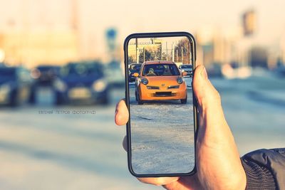 Man photographing car on street