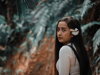 Portrait of young woman looking away outdoors