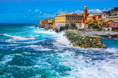 Rough sea  big waves crash  small port  nervi in genoa  italian riviera liguria  beautiful sunny day