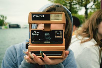 Close-up of woman photographing with mobile phone