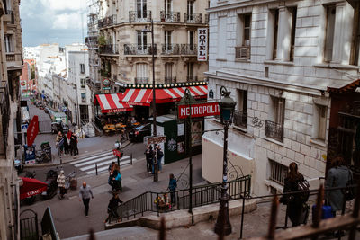 People walking on street against buildings in city