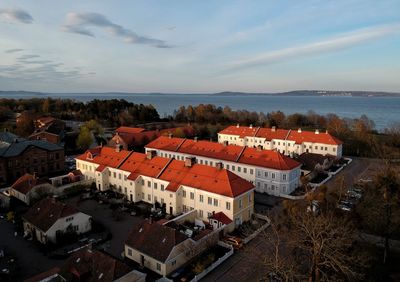 High angle view of townscape by sea against sky