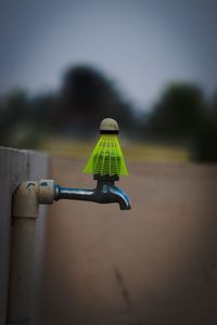 Close-up of water pipe on field against sky