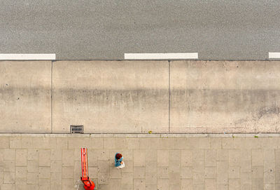 High angle view of people walking on footpath against building