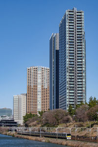 Modern buildings in city against clear blue sky