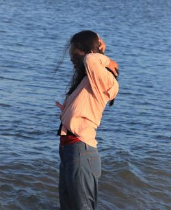 Side view of woman standing in sea