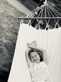 High angle view portrait of smiling girl lying on hammock