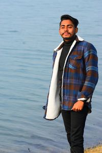 Portrait of young man standing in water