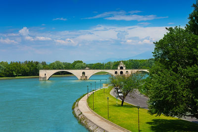 Arch bridge over river against sky