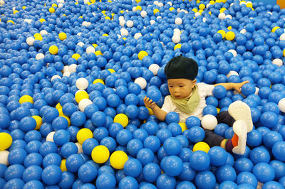 High angle view of baby boy amidst balls