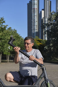 Senior man fixing electric scooter