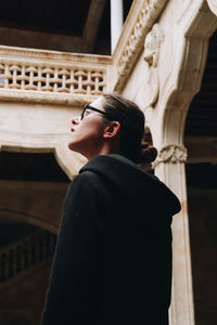 Side view of man looking through window