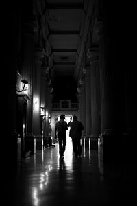 People walking in illuminated corridor