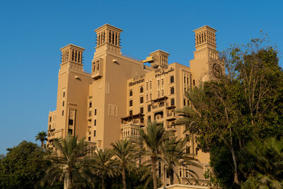 Low angle view of palm trees and building against sky