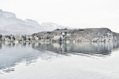 Scenic view of lake by buildings against sky