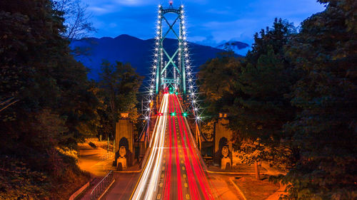 Cars on illuminated mountain against sky at night