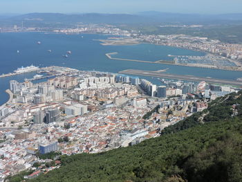 High angle view of cityscape by sea against sky