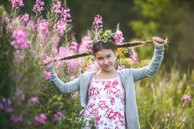 Woman standing by pink flowering plants