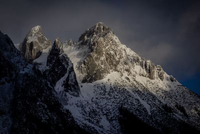 Low angle view of snowcapped mountains against sky