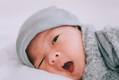 Close-up of cute baby boy lying on bed